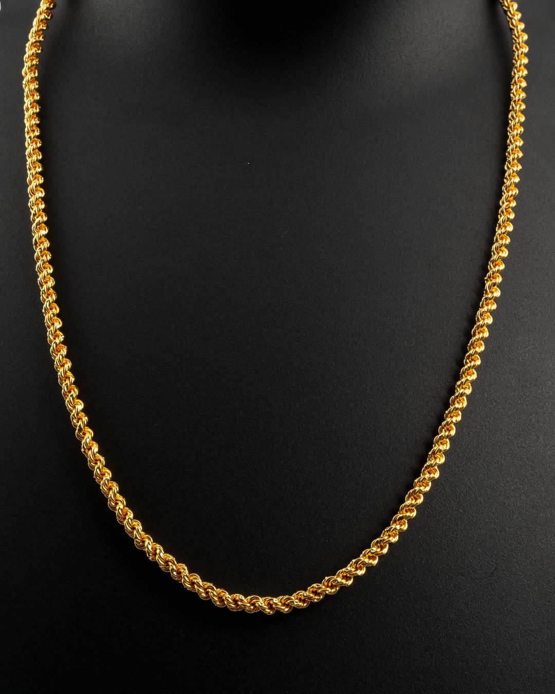 Gold chain necklace on a black background