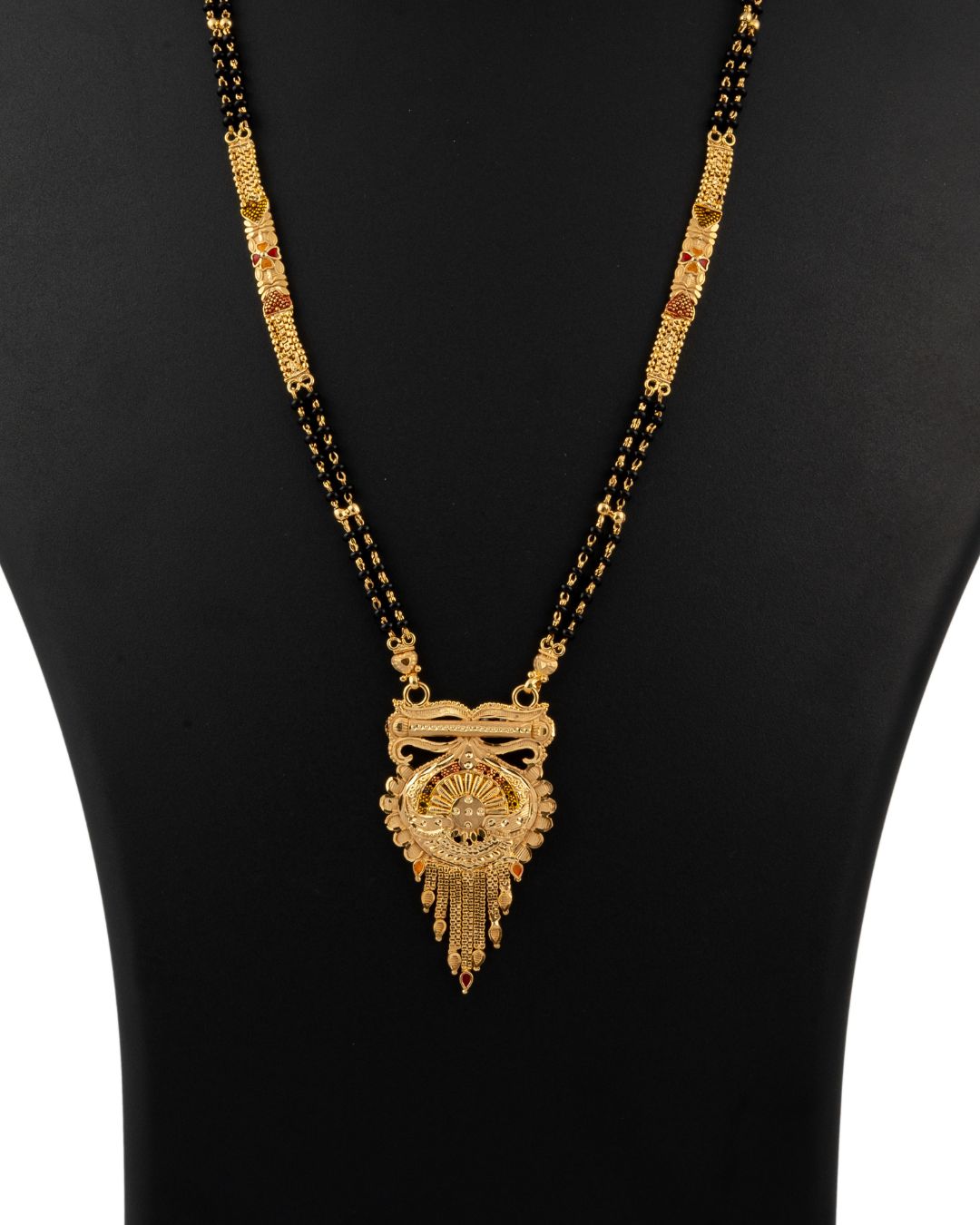 Gold necklace with a pendant on a black background