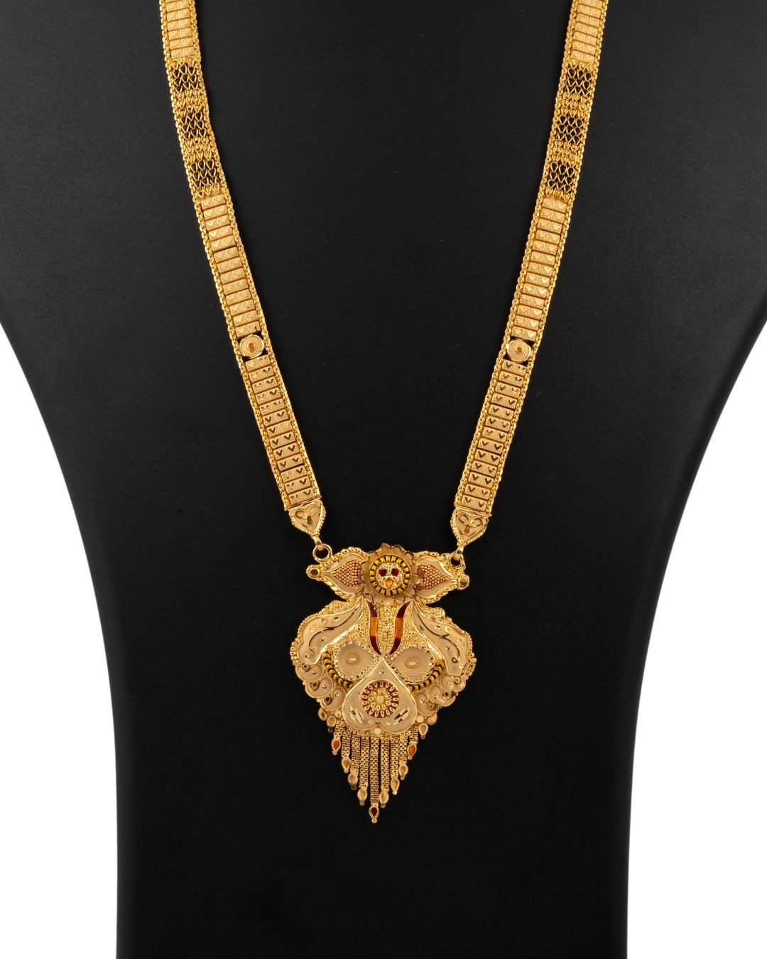 Gold necklace with a heart-shaped pendant on a black background