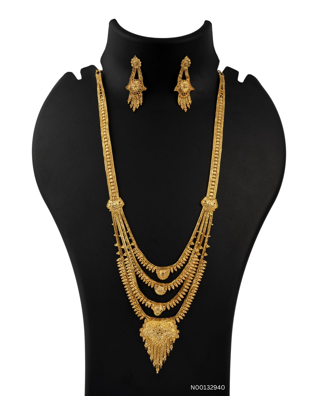 Gold necklace and earrings set on a black mannequin bust with a white background