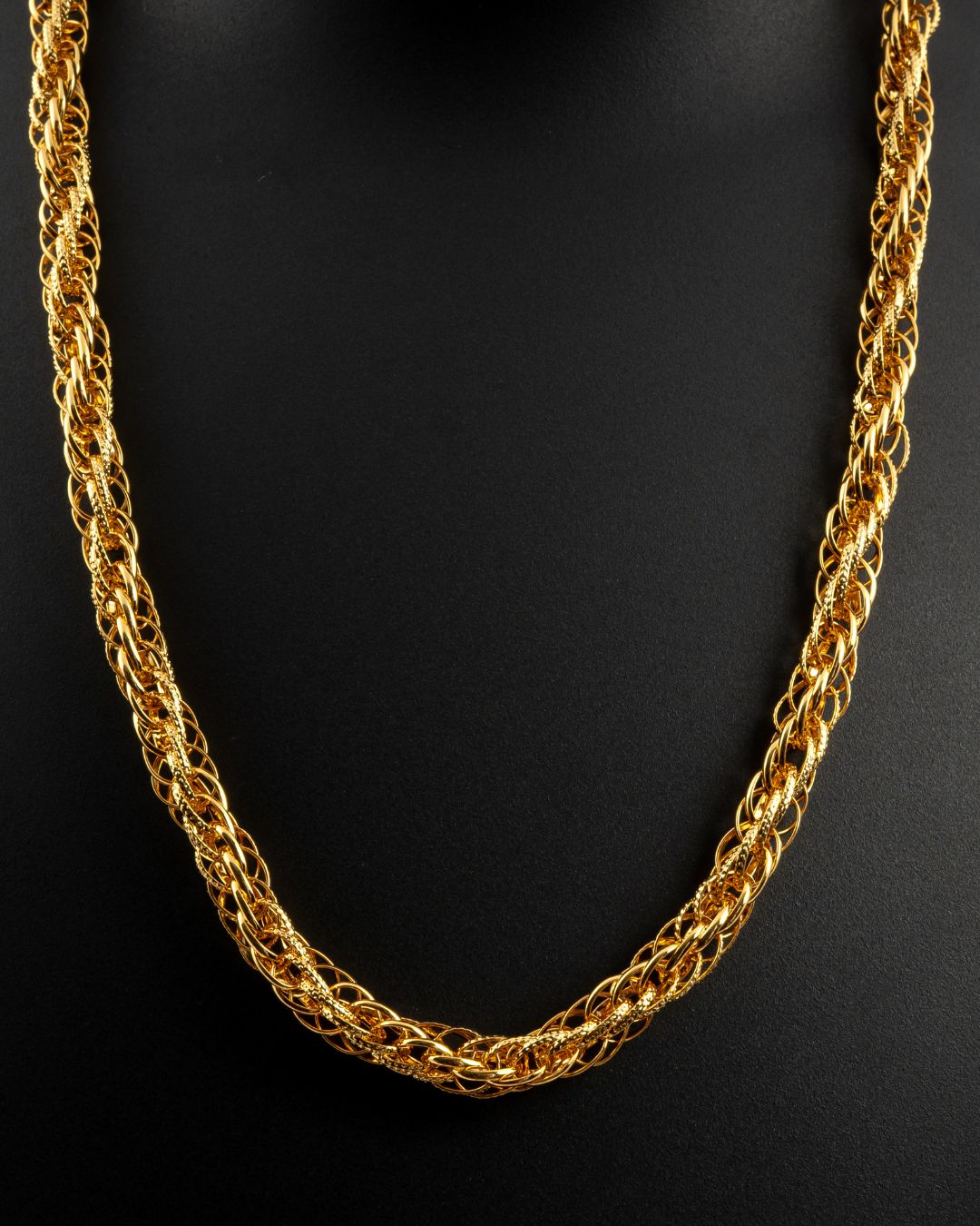 Gold chain necklace on a black background