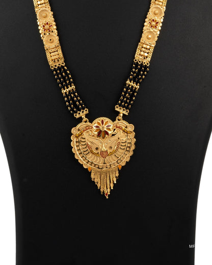 Gold necklace with a large decorative pendant on a black background