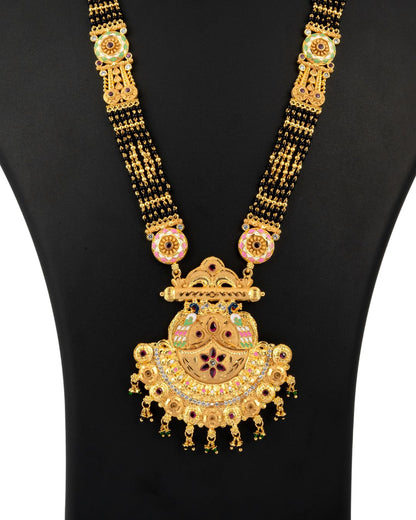 Gold necklace with intricate design on a black background