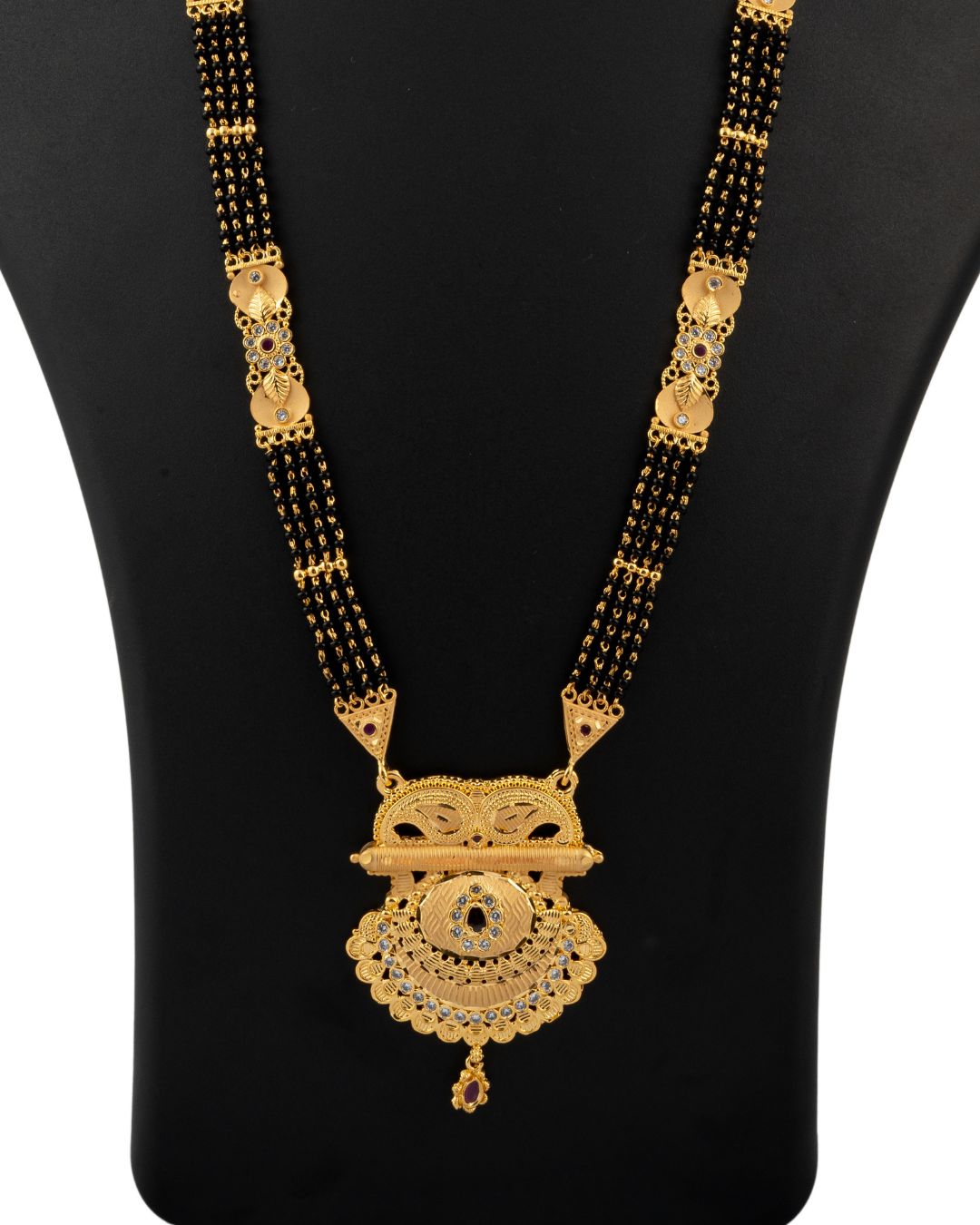 Gold and black necklace on a black mannequin