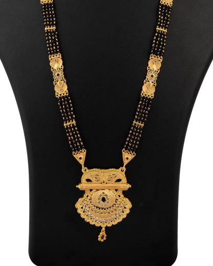 Gold and black necklace on a black mannequin