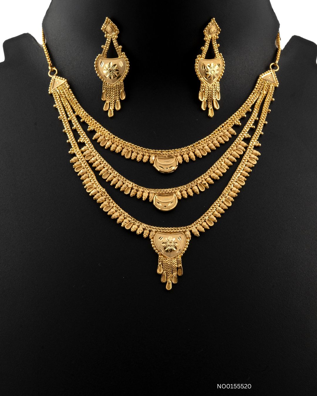 Gold necklace and earrings set on a black background