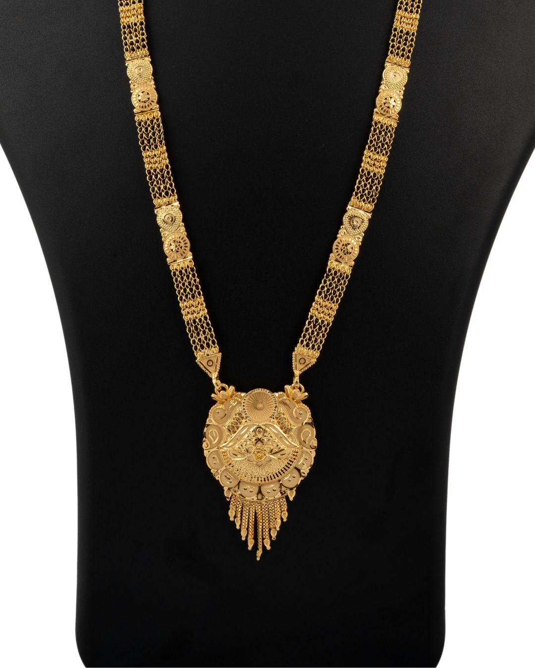Gold necklace with intricate design on a black mannequin