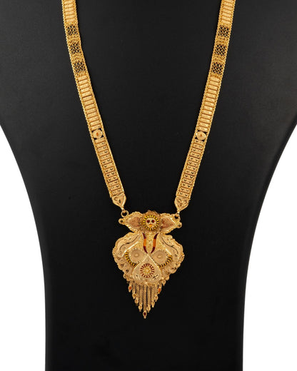Gold necklace with a heart-shaped pendant on a black background