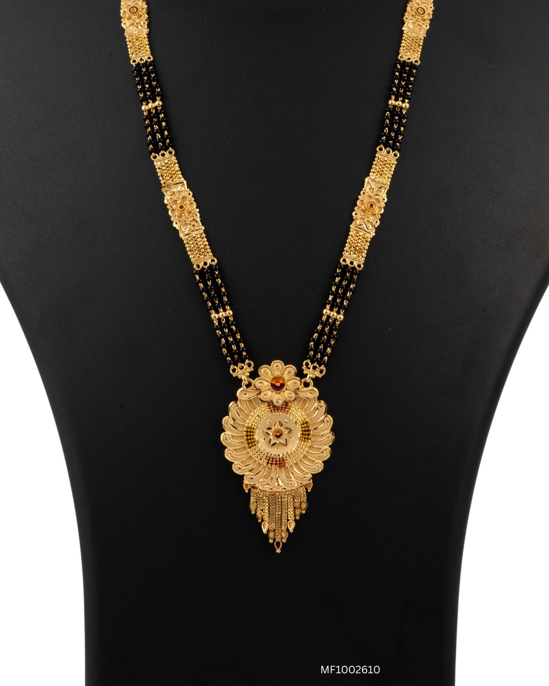 Gold necklace with a decorative pendant on a black background