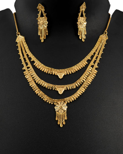 Gold necklace and earrings set on a black background
