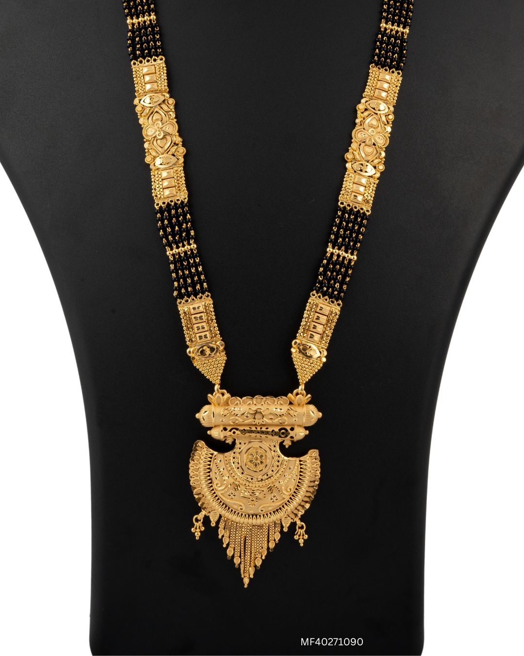 Gold necklace with black beads on a black mannequin