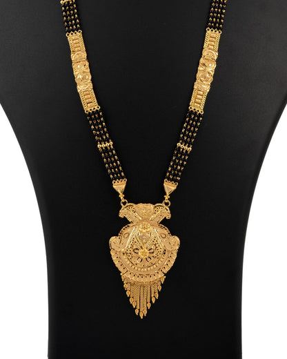 Gold necklace with a large pendant on a black mannequin