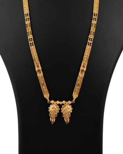 Gold necklace with intricate design on a black mannequin