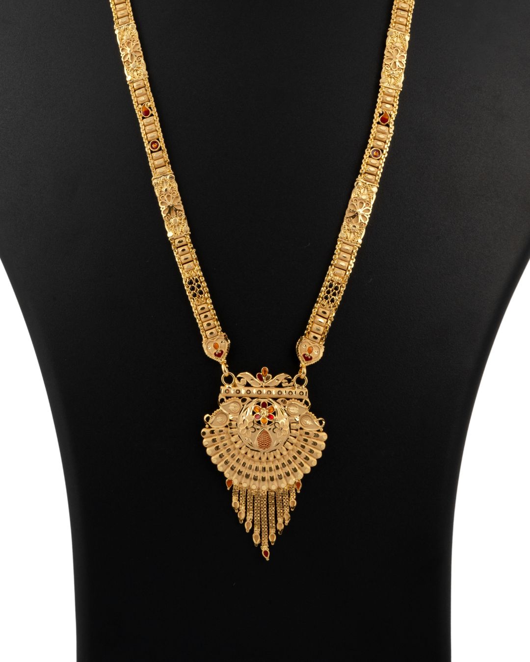 Gold necklace with a heart-shaped pendant on a black background