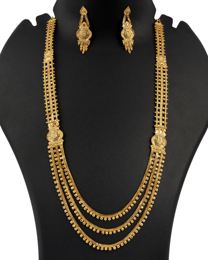Gold necklace and earrings set on a black mannequin