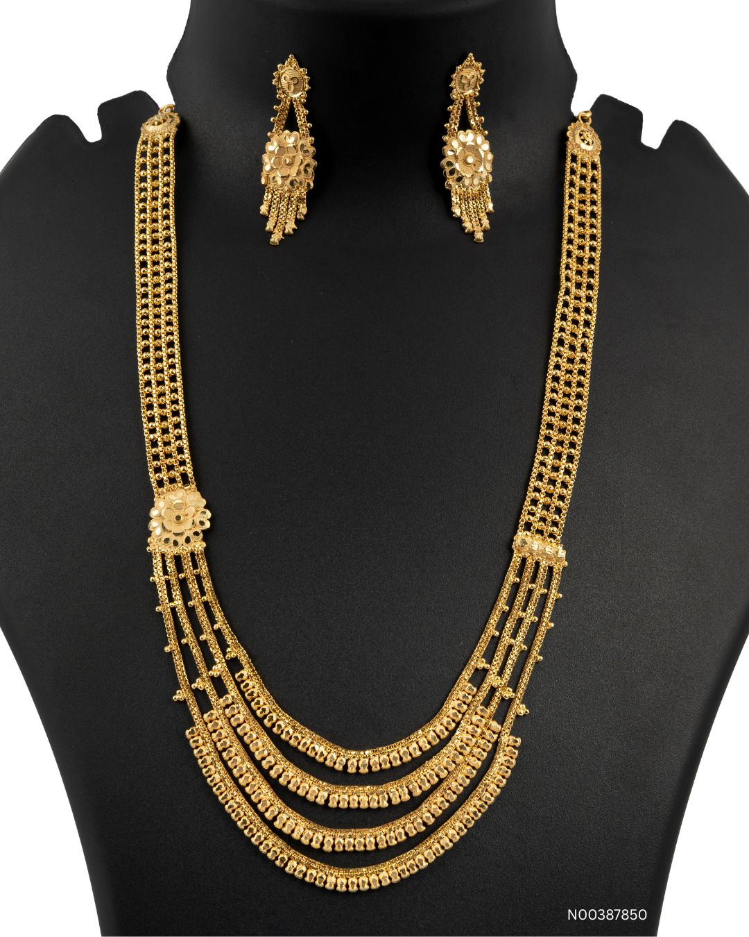 Gold necklace and earrings set on a black mannequin